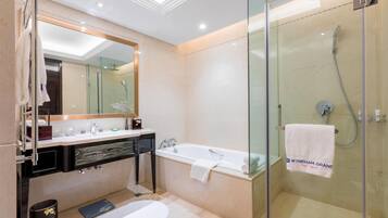 A modern bathroom with a glass-enclosed shower, a bathtub, and a vanity with a mirror.