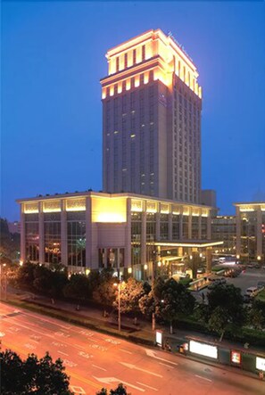 Un hotel de gran altura con una torre central destacada, varios pisos y una fachada bien iluminada.