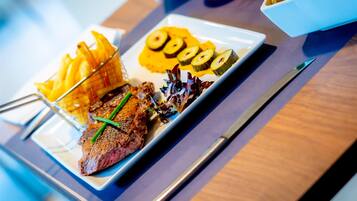 Een bord eten met steak, friet en groenten.