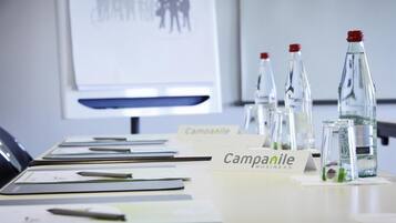 A conference room with a whiteboard, name tags, and water bottles on a table.