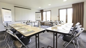 A conference room with multiple tables, chairs, and presentation screens. - Campanile NATURE - Vierzon (Vierzon)