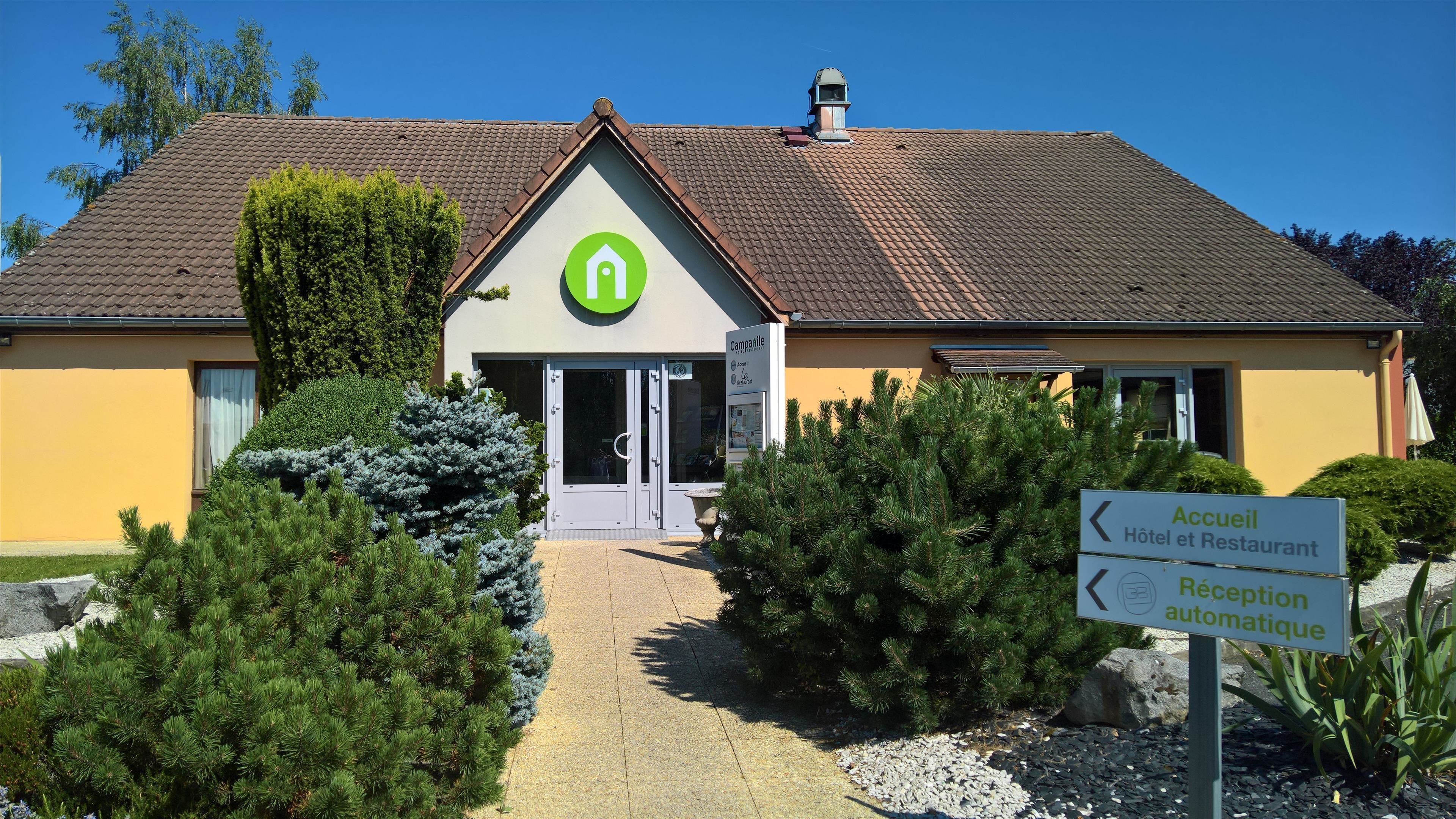 A hotel with a green logo, a reception area, and a sign indicating an automatic reception.