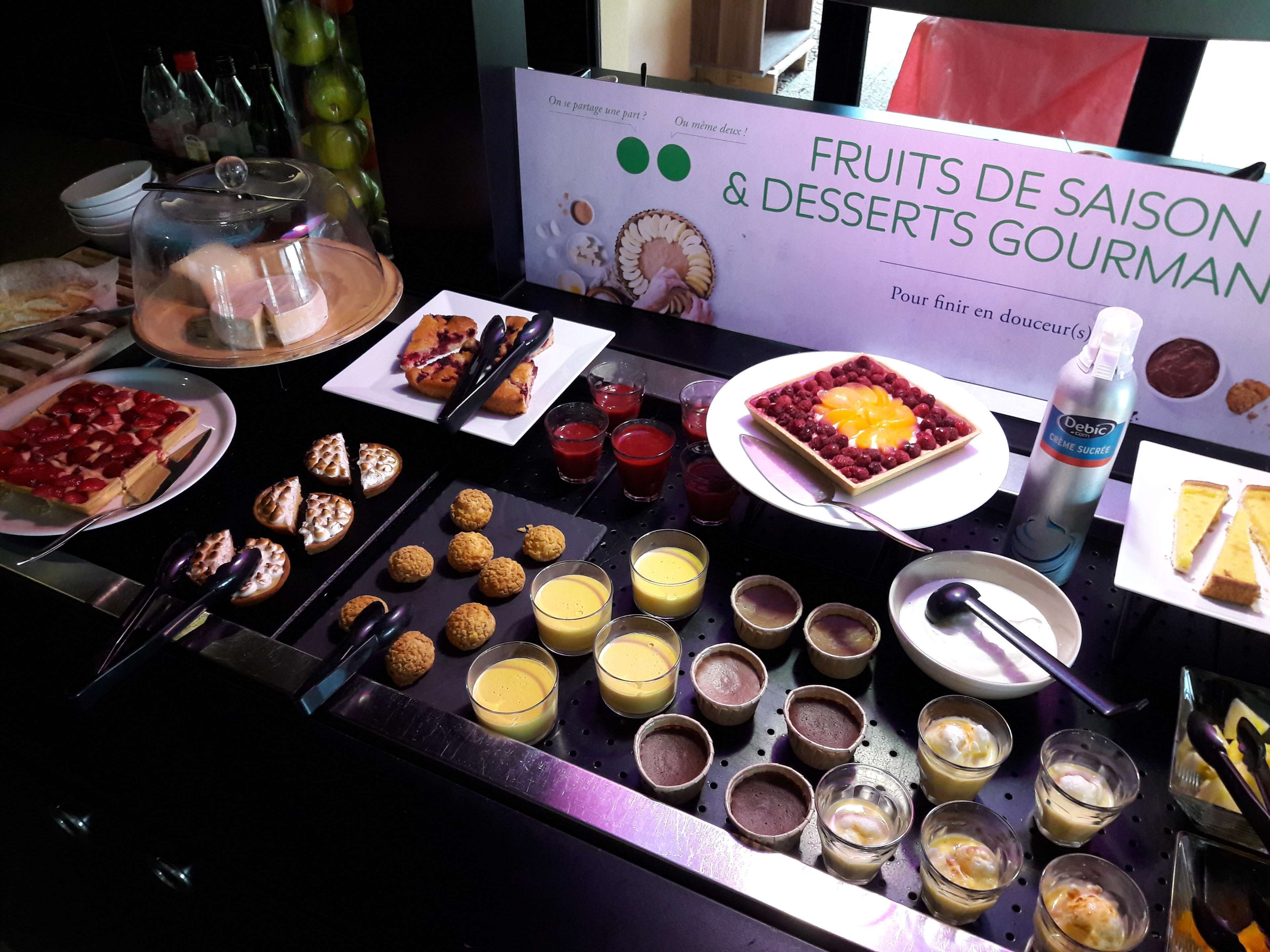 A buffet table with various desserts and fruits.