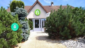L’entrée d’un hôtel, avec un logo vert, une enseigne indiquant « Hôtel et restaurant Campanile » et un badge « Établissement propre et sûr ».