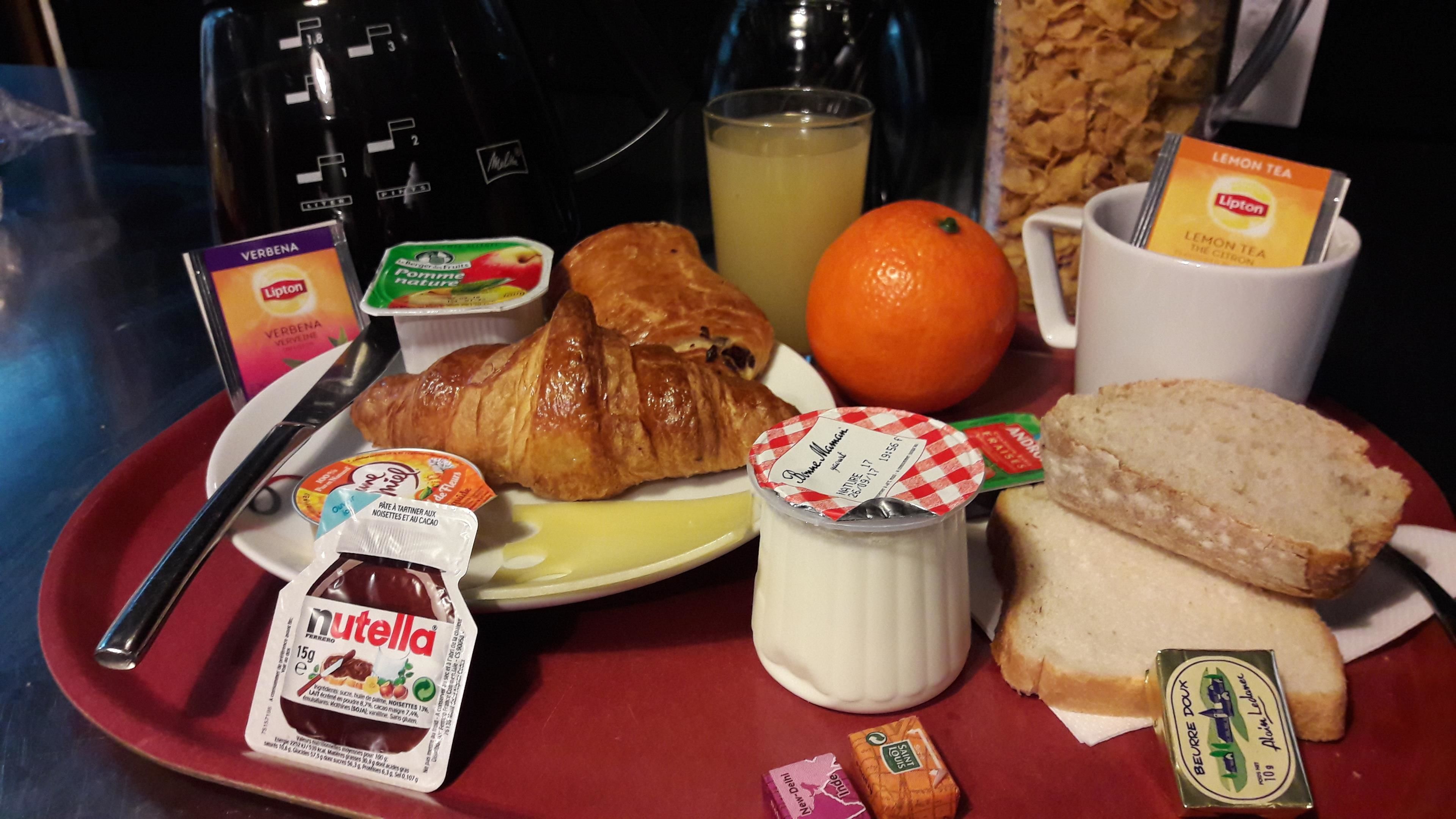 Een ontbijfwagen met croissants, sinaasappelsap, Nutella, yoghurt en brood.