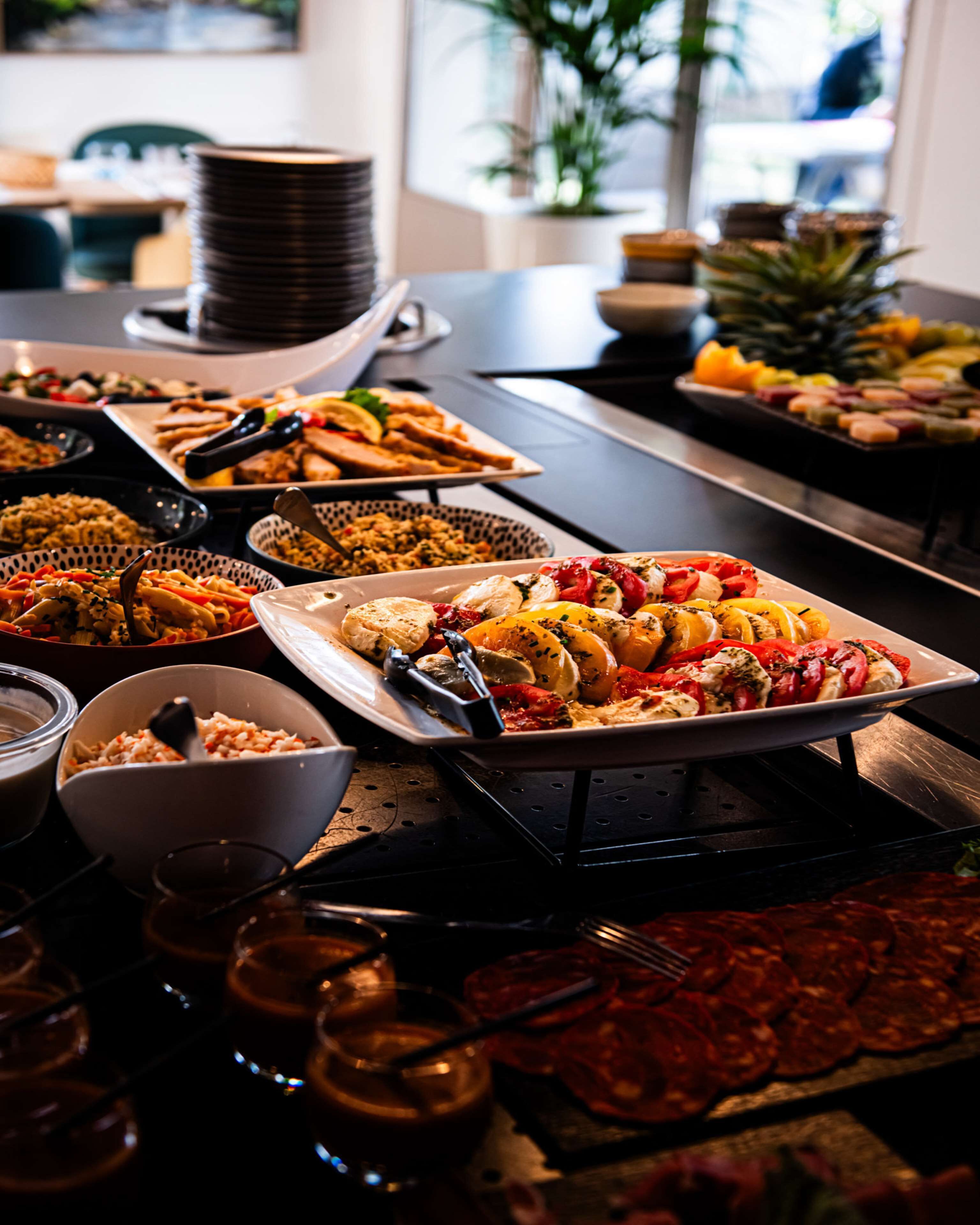 A buffet table with various dishes, including grilled vegetables, meats, and salads.