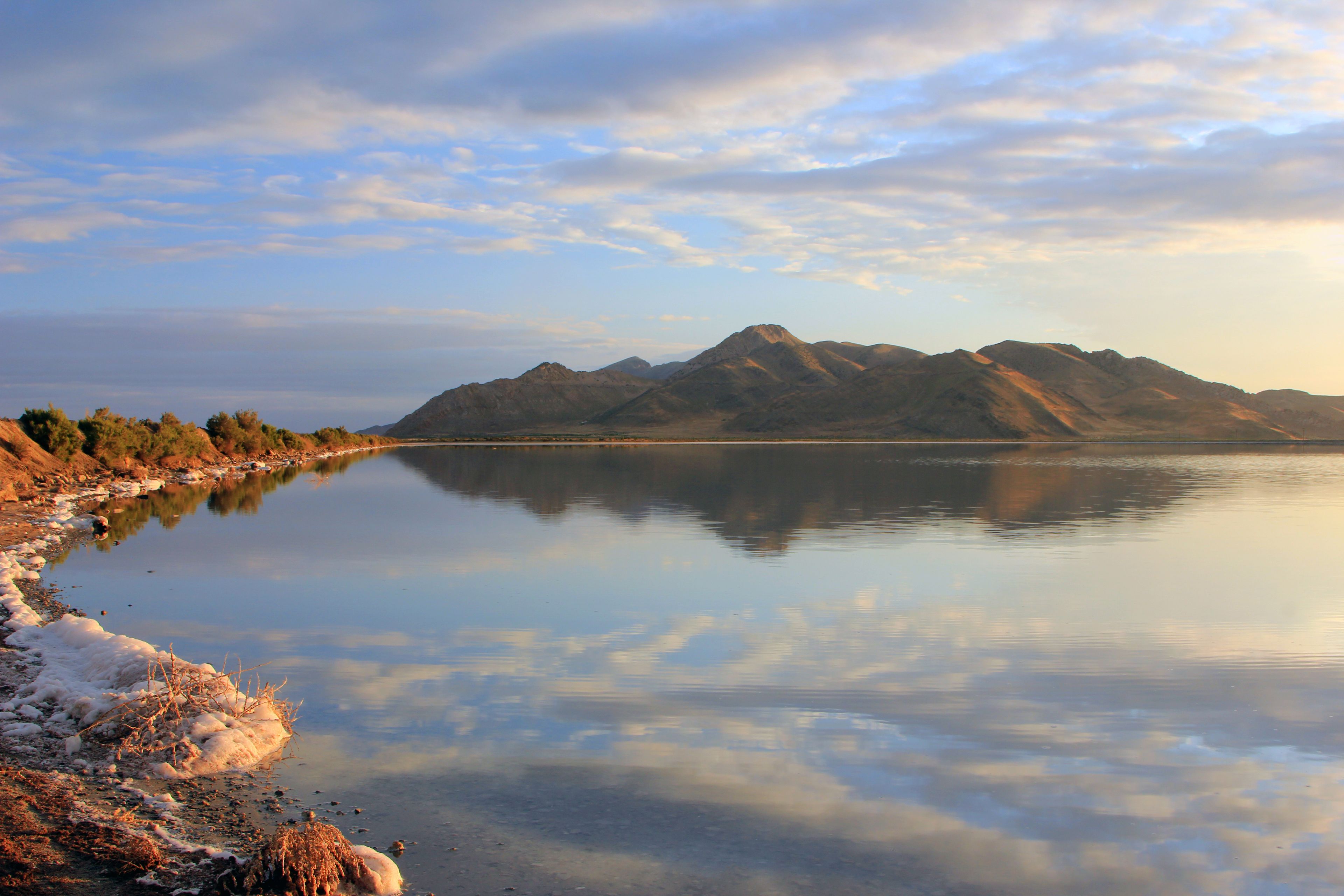 A calm lake with mountains in the background.