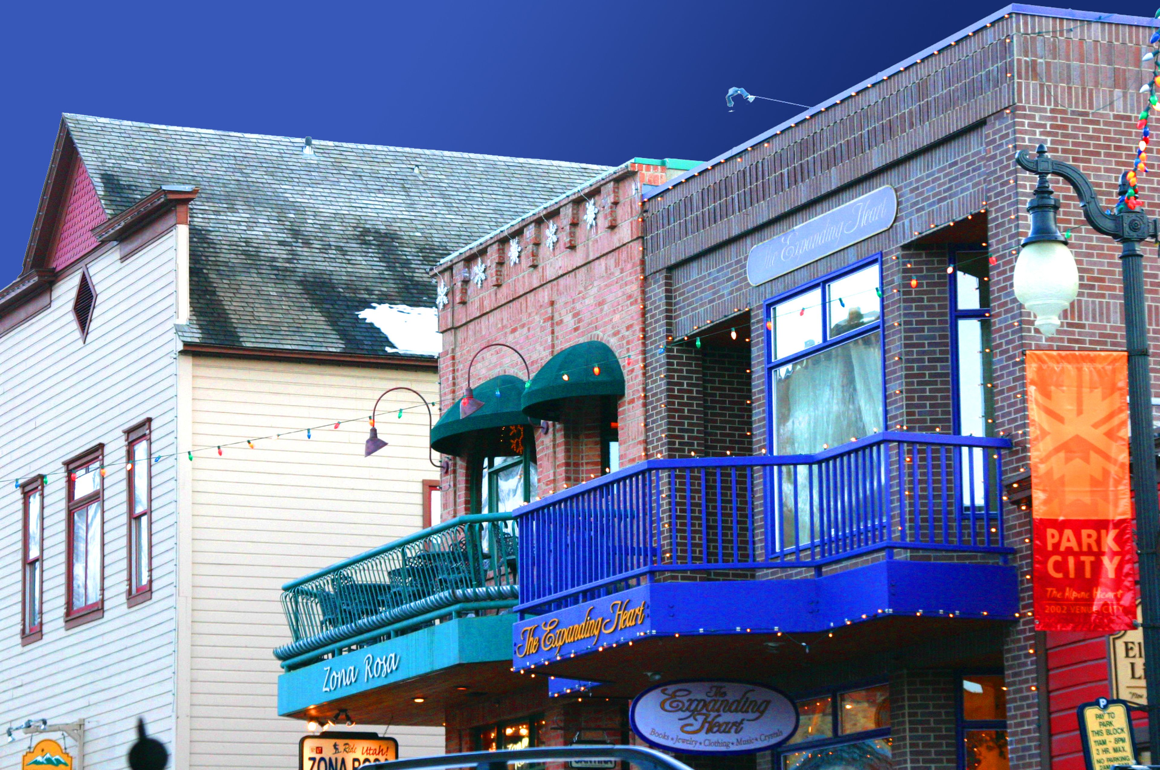 A building with a balcony and a sign that reads "The Expanding Heart."