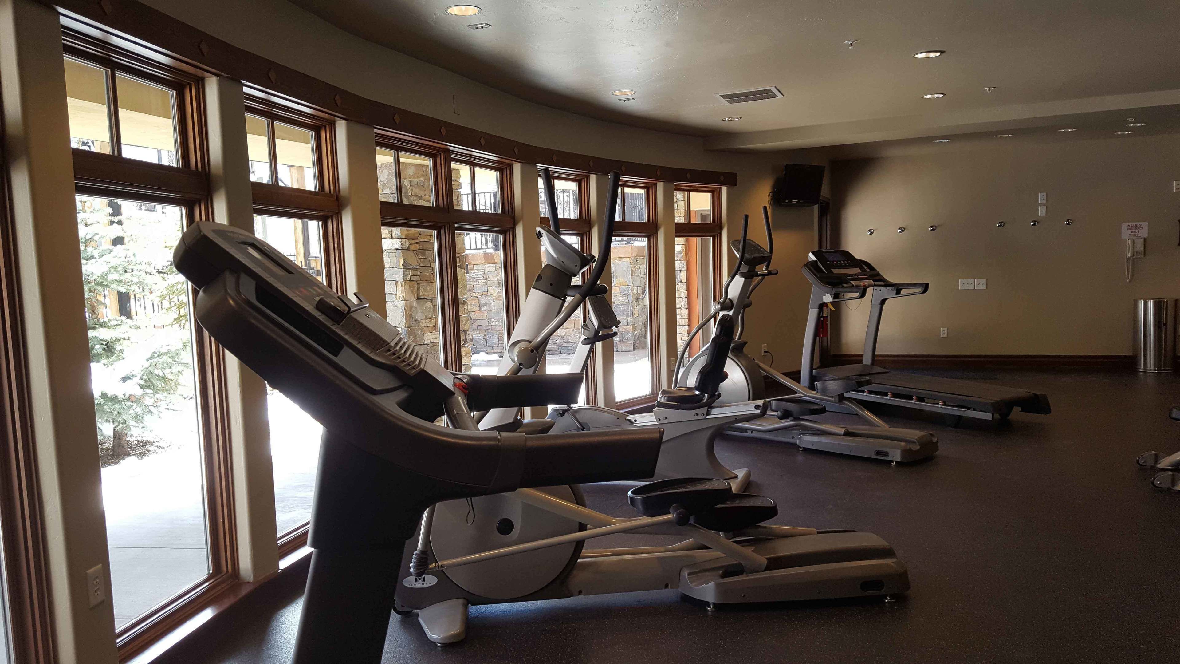 A gym with treadmills, elliptical machines, and a stationary bike.