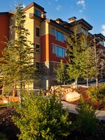 A multi-story building with a modern architectural design, featuring large windows and a stone facade.