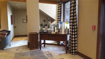 A hotel lobby with a reception desk, a water dispenser, and a fire alarm.
