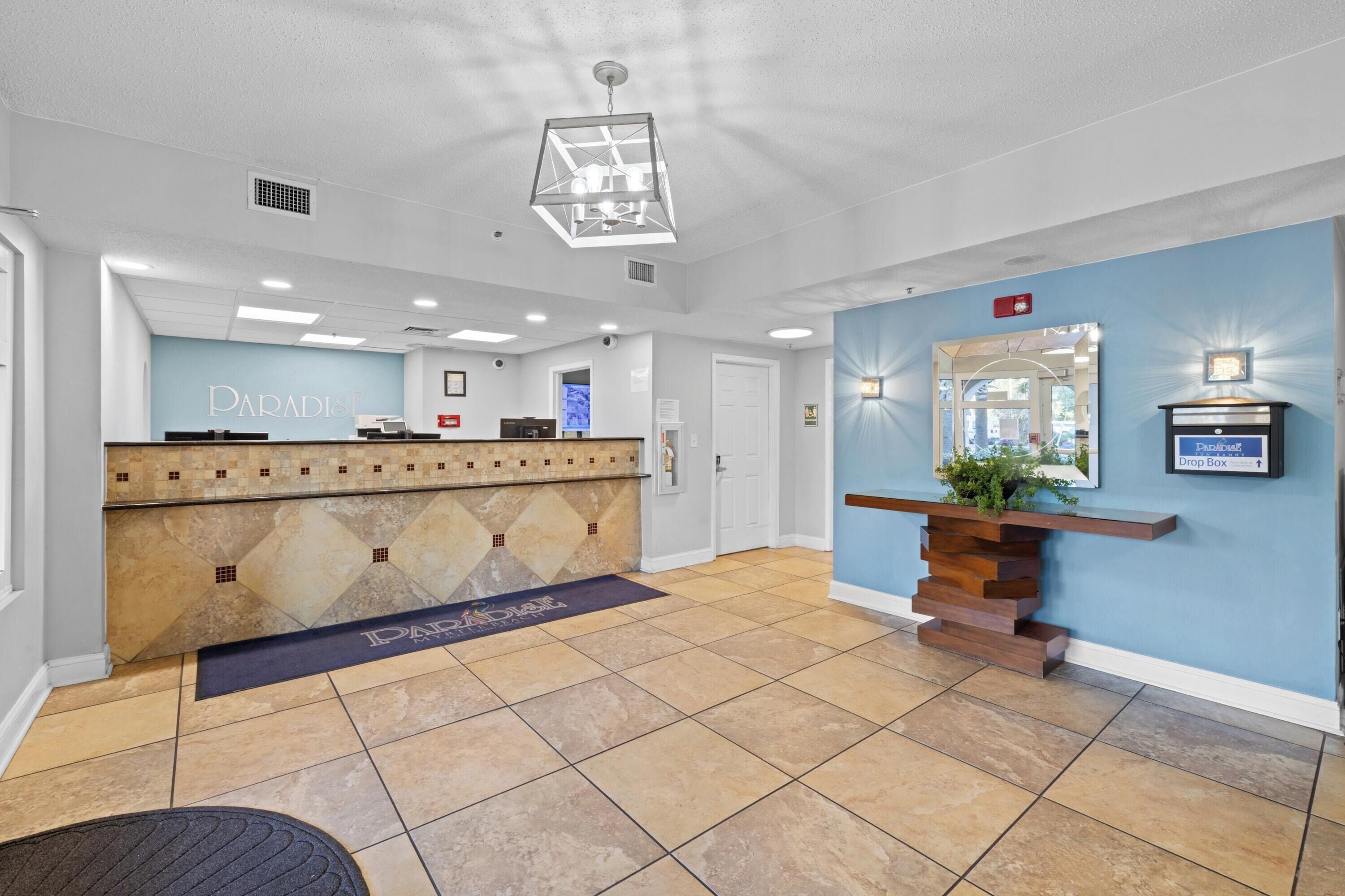A reception area with a counter, a drop box, and a wall-mounted mirror.