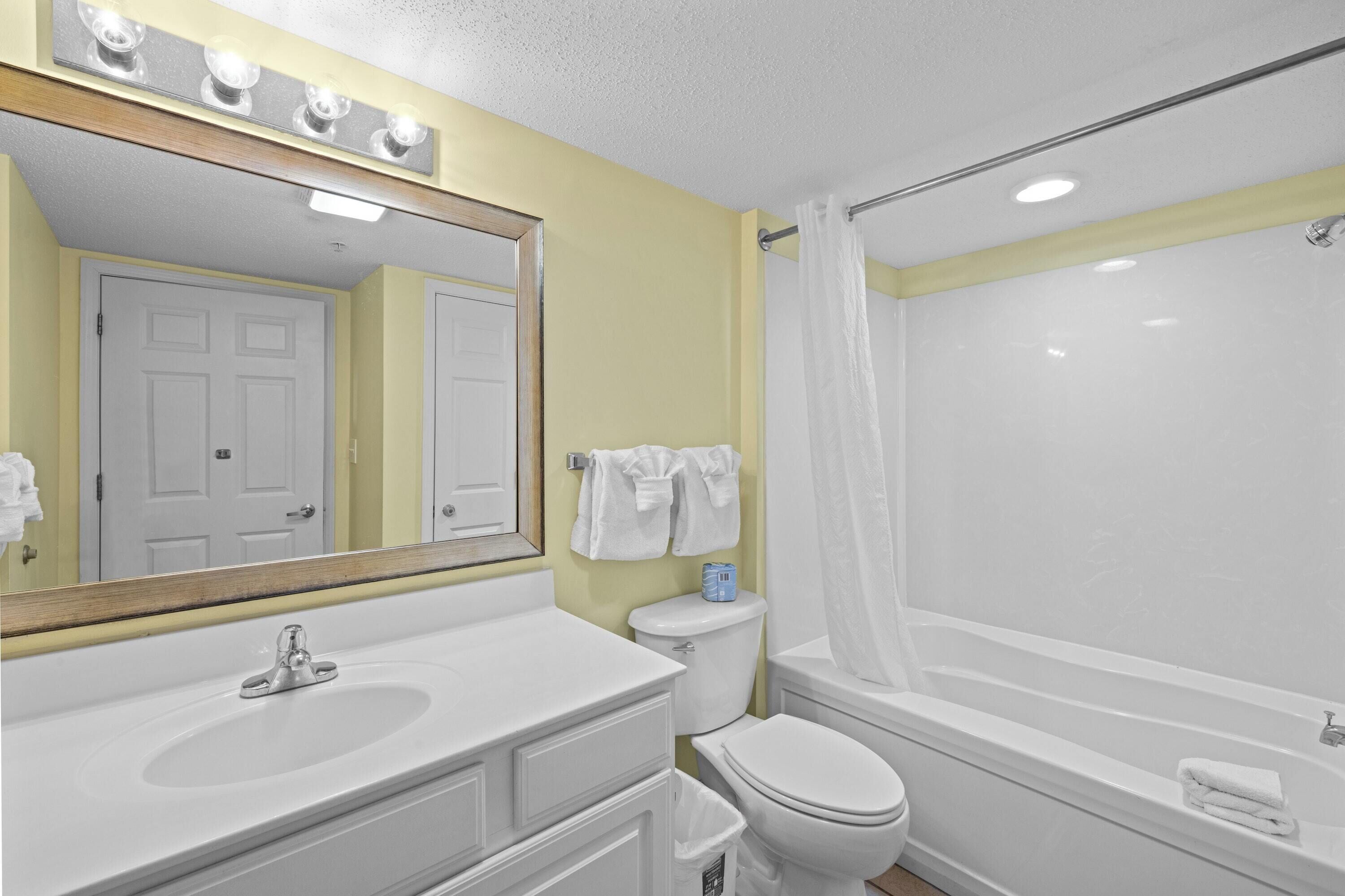 A bathroom with a sink, toilet, and bathtub.