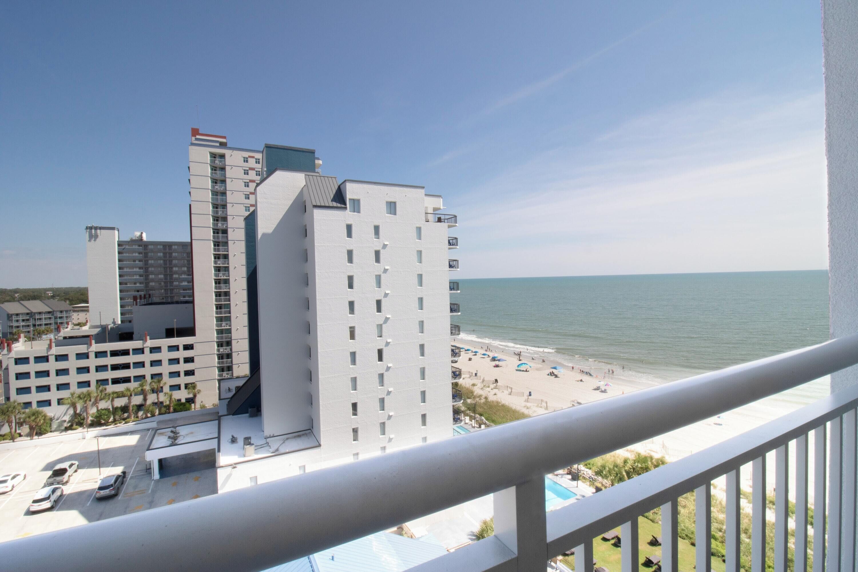 A high-rise hotel with a view of the beach and ocean.