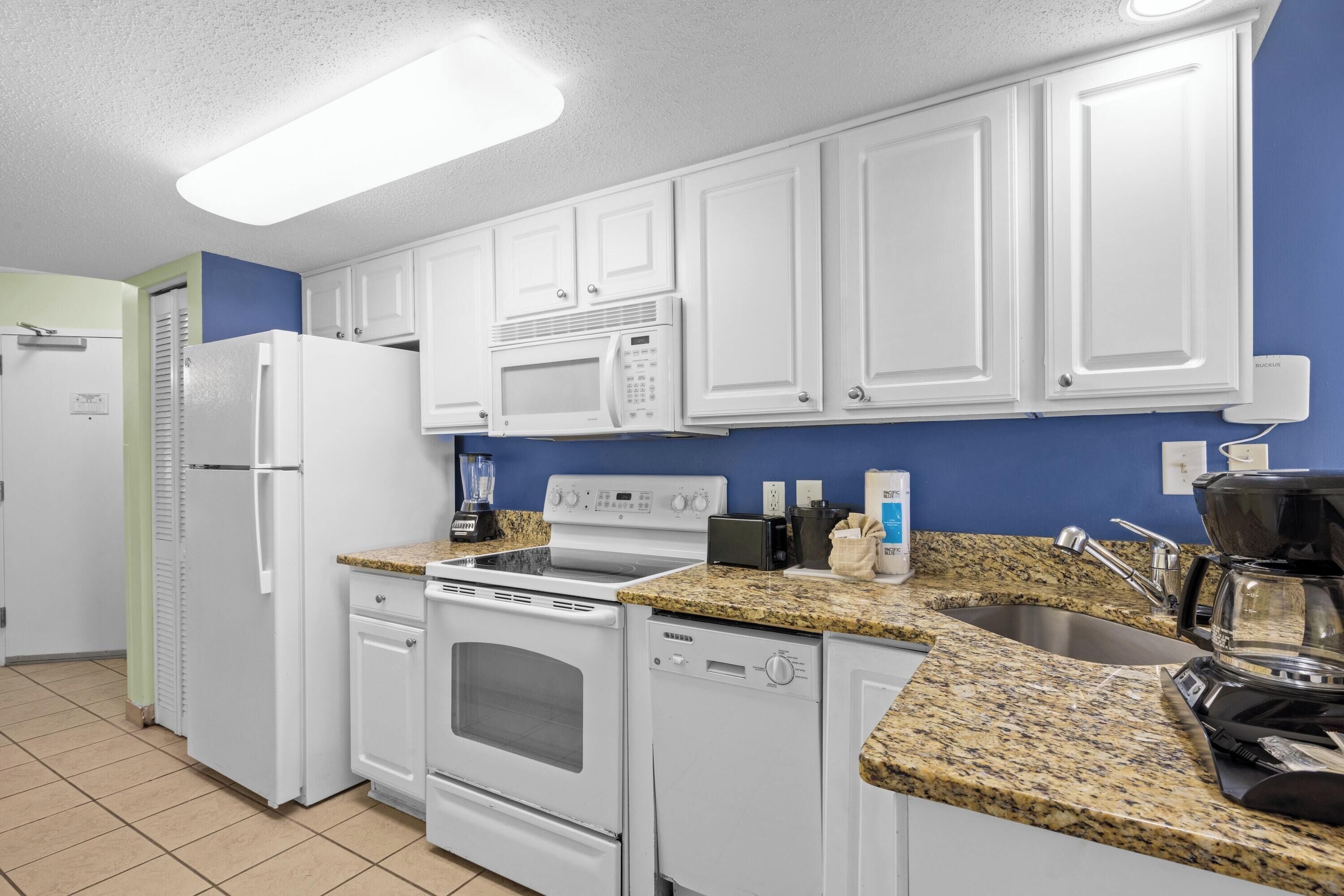 A kitchen with white cabinets, a microwave, a stove, a dishwasher, and granite countertops.