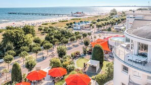 A coastal hotel with outdoor seating, a pier, and beach access.