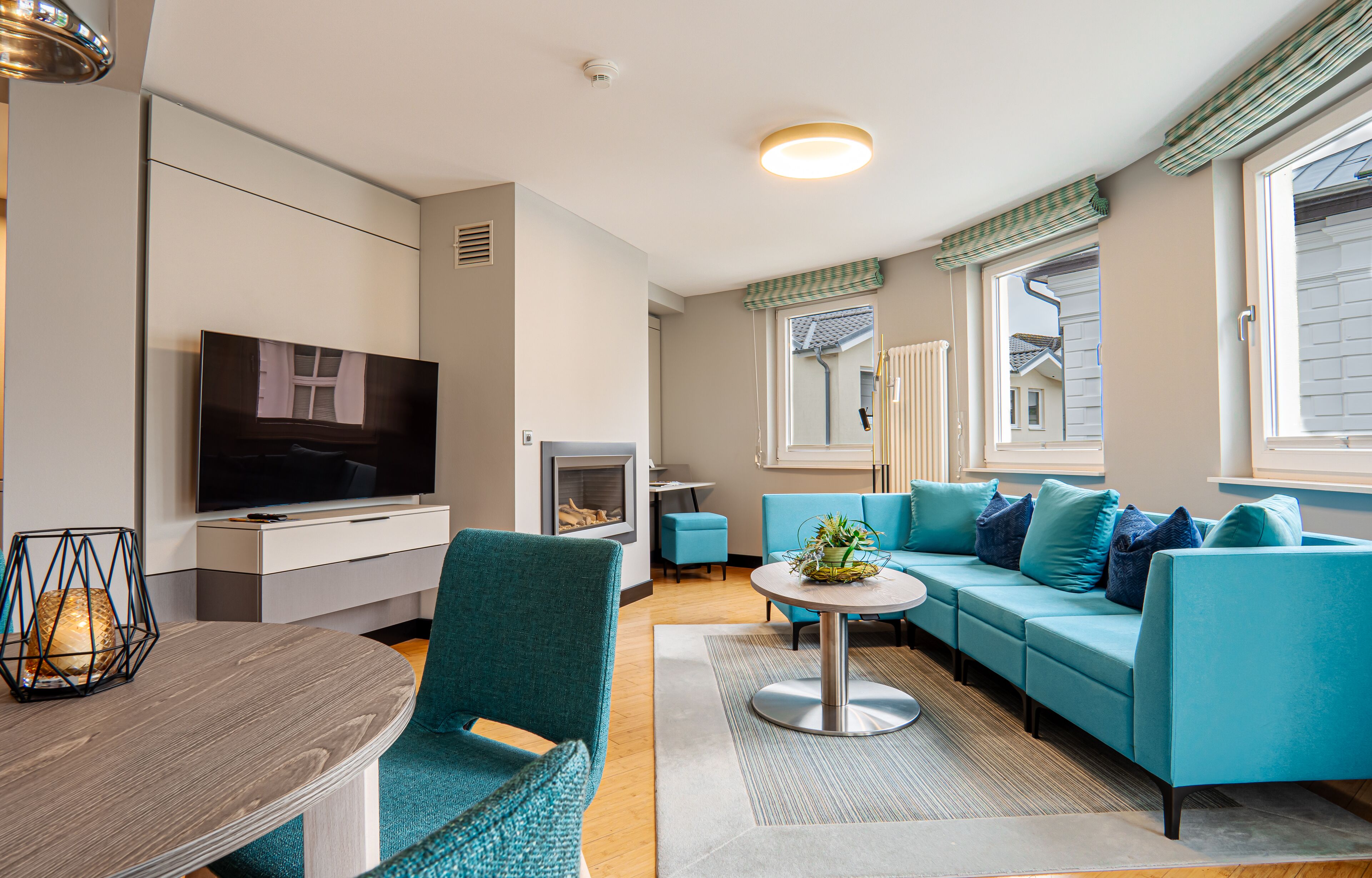 Una sala de estar moderna con un conjunto de sofás, un televisor, una chimenea y una zona de comedor.