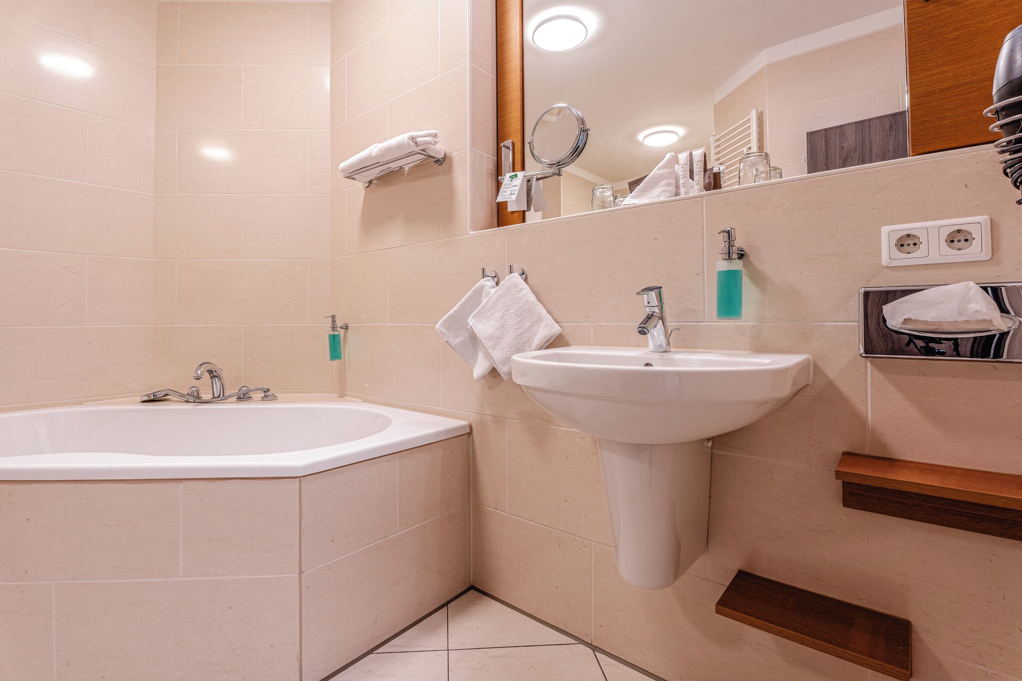 Une salle de bain moderne avec une baignoire, un lavabo et un miroir.