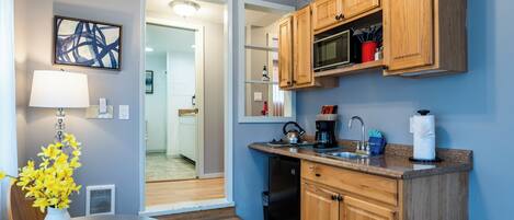 A modern kitchen with wooden cabinets, a built-in microwave, and a sink.