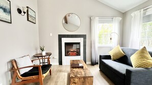 Una sala de estar con chimenea, un sofá, una mesa de centro y un sillón.