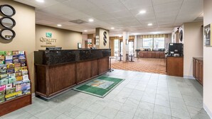 A hotel reception area with a reception desk, a bulletin board with local information, and a kitchen area in the background. - Quality Inn Heber Springs (Heber Springs)
