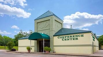 A building labeled "Conference Center" with a green roof, a clock, and a covered entrance.