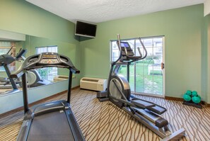 A gym with treadmills, a stationary bike, and a TV mounted on the wall. - Days Inn by Wyndham Petoskey (Petoskey)