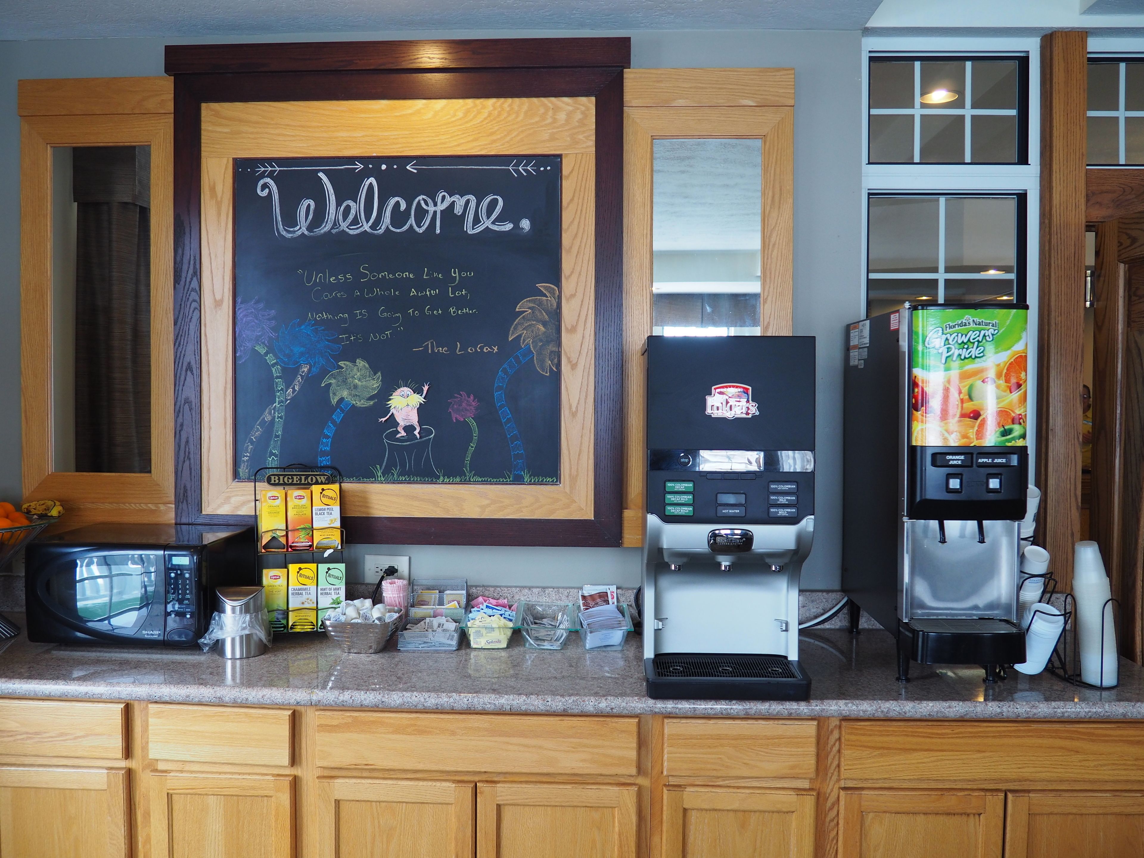 A kitchen counter with a coffee machine, a microwave, and a refrigerator.