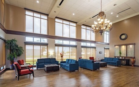 A spacious lobby with large windows, a chandelier, and multiple seating areas.