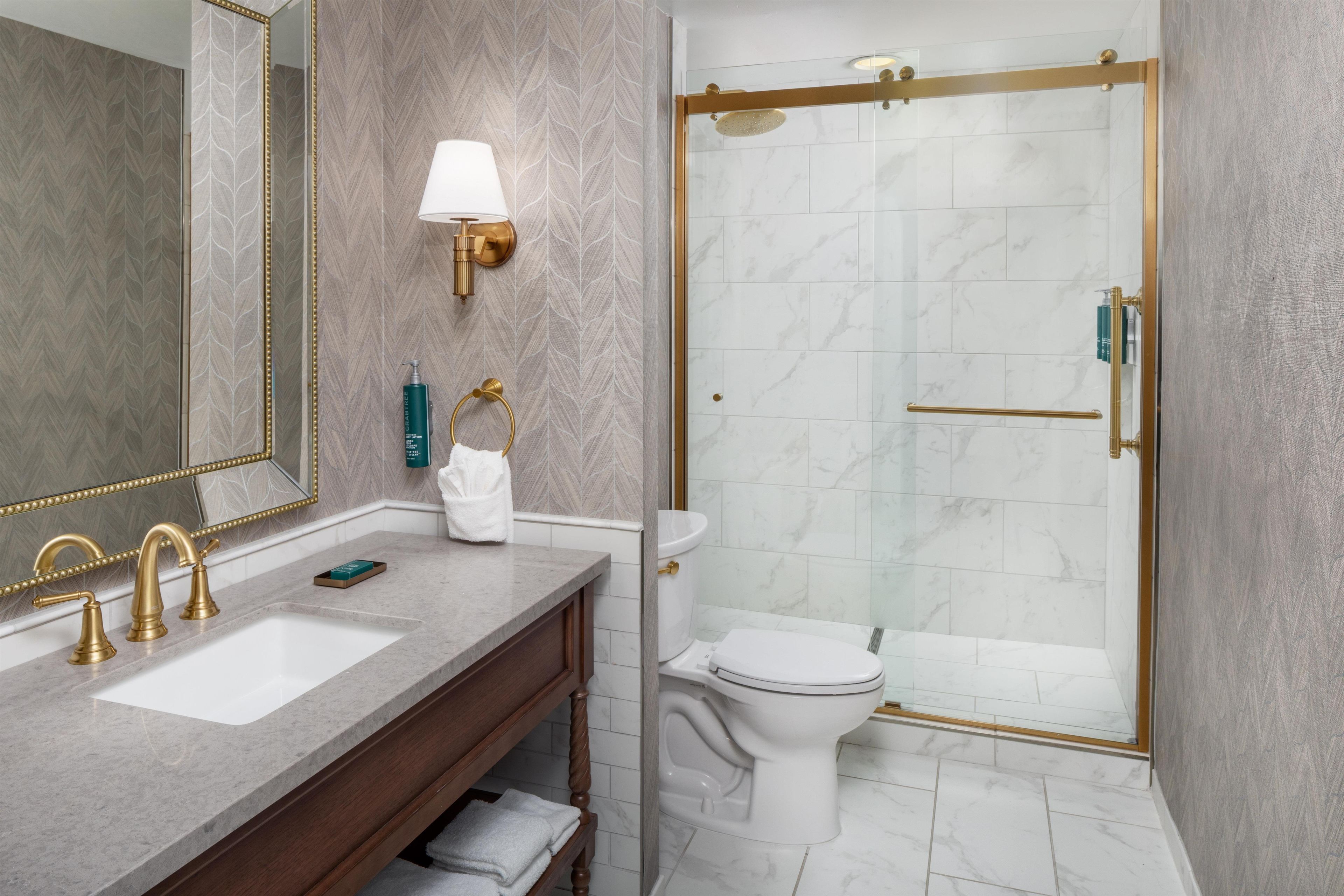 Une salle de bain équipée d’un meuble-lavabo, de toilettes et d’une douche.