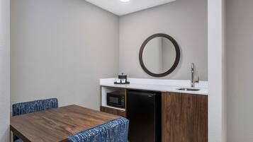 A compact kitchenette with a microwave, refrigerator, and sink.