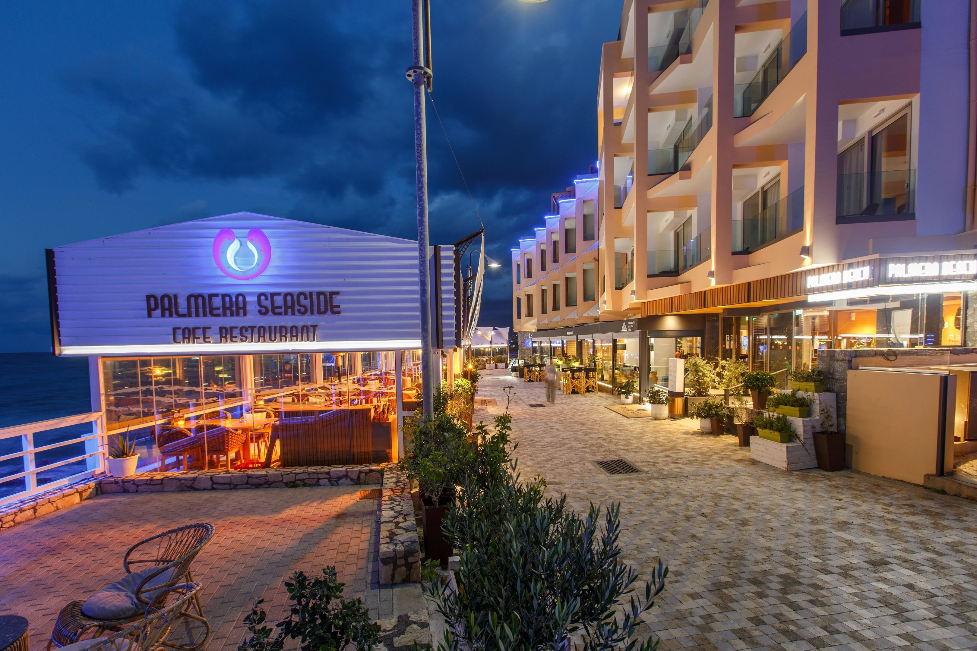 A beachfront restaurant with outdoor seating and a view of the sea.