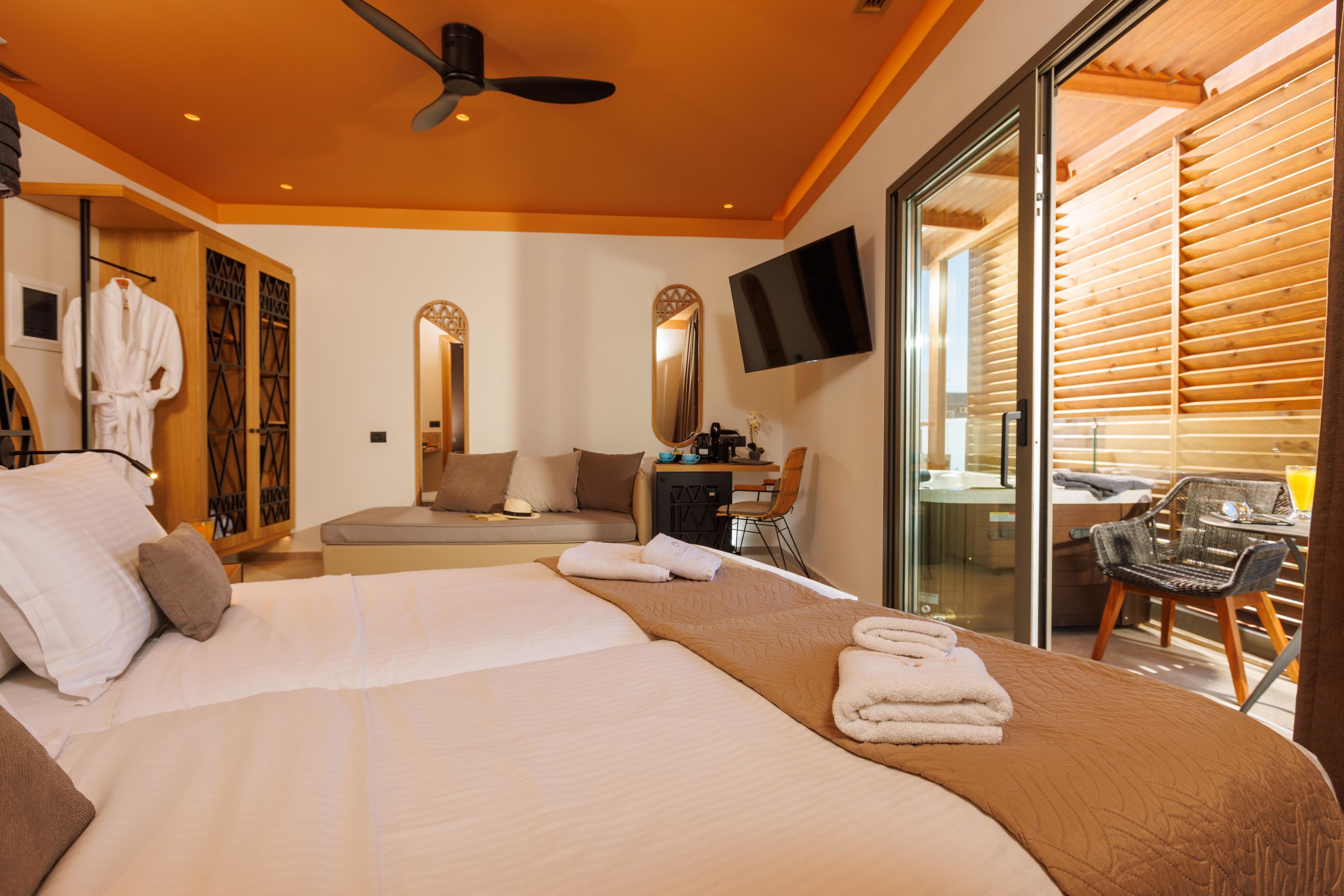 Una habitación de hotel moderna con una cama grande, un escritorio, una silla y un televisor.