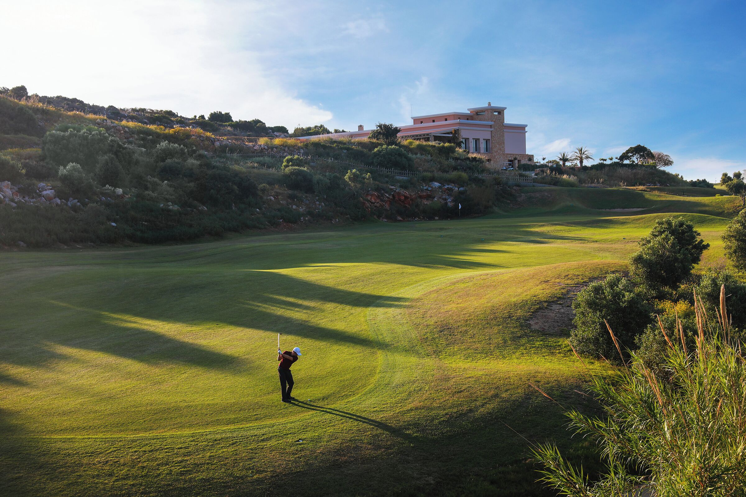 A golf course with a building in the background.