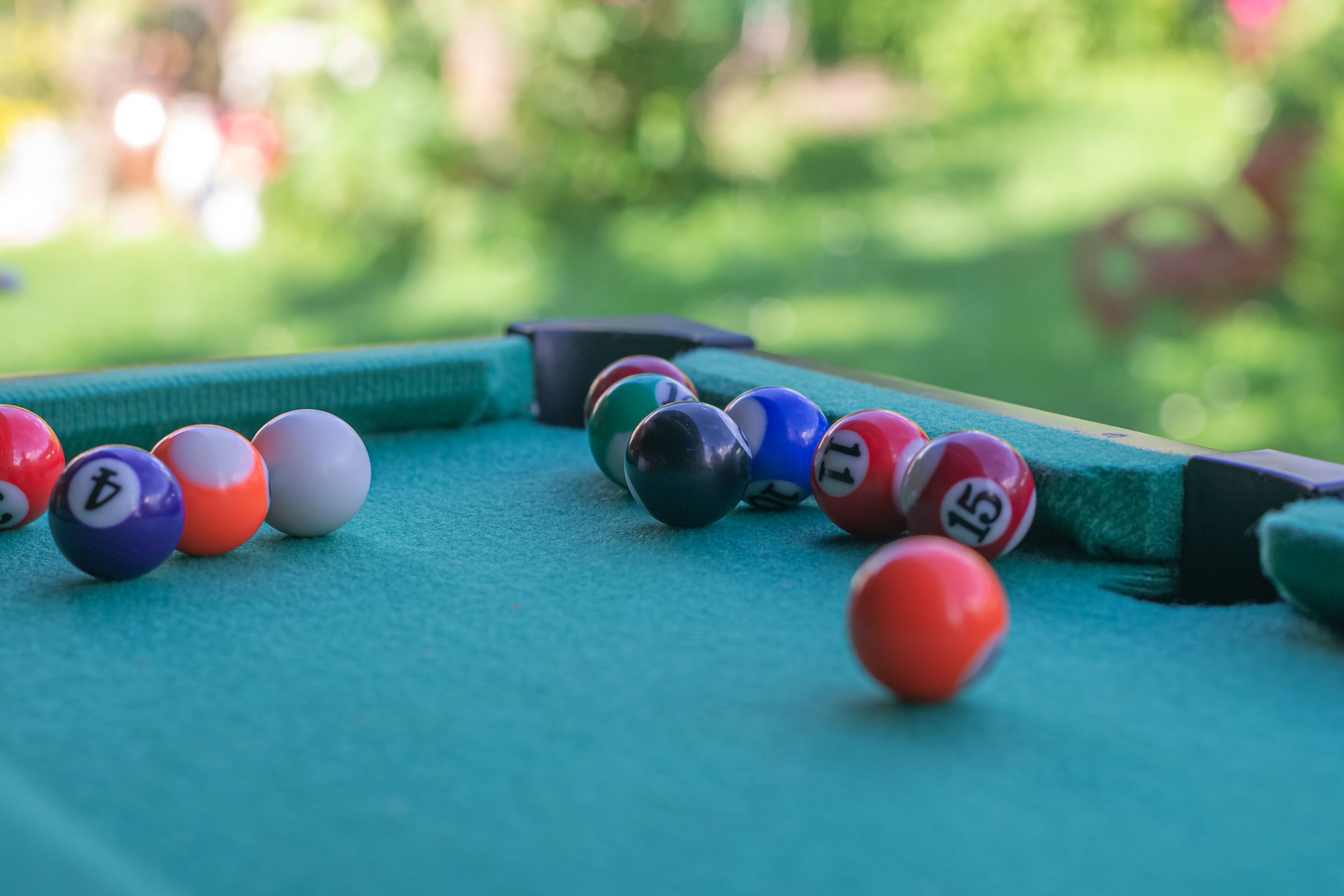 A pool table with various colored balls and a cue stick.