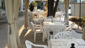 An outdoor dining area with tables and chairs under a canopy. - Hotel San Marco & Formula Club (Noceto)