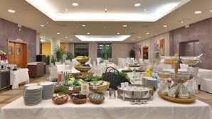 A buffet setup with various food items and utensils, arranged on tables with white tablecloths. - Hotel San Marco & Formula Club (Noceto)