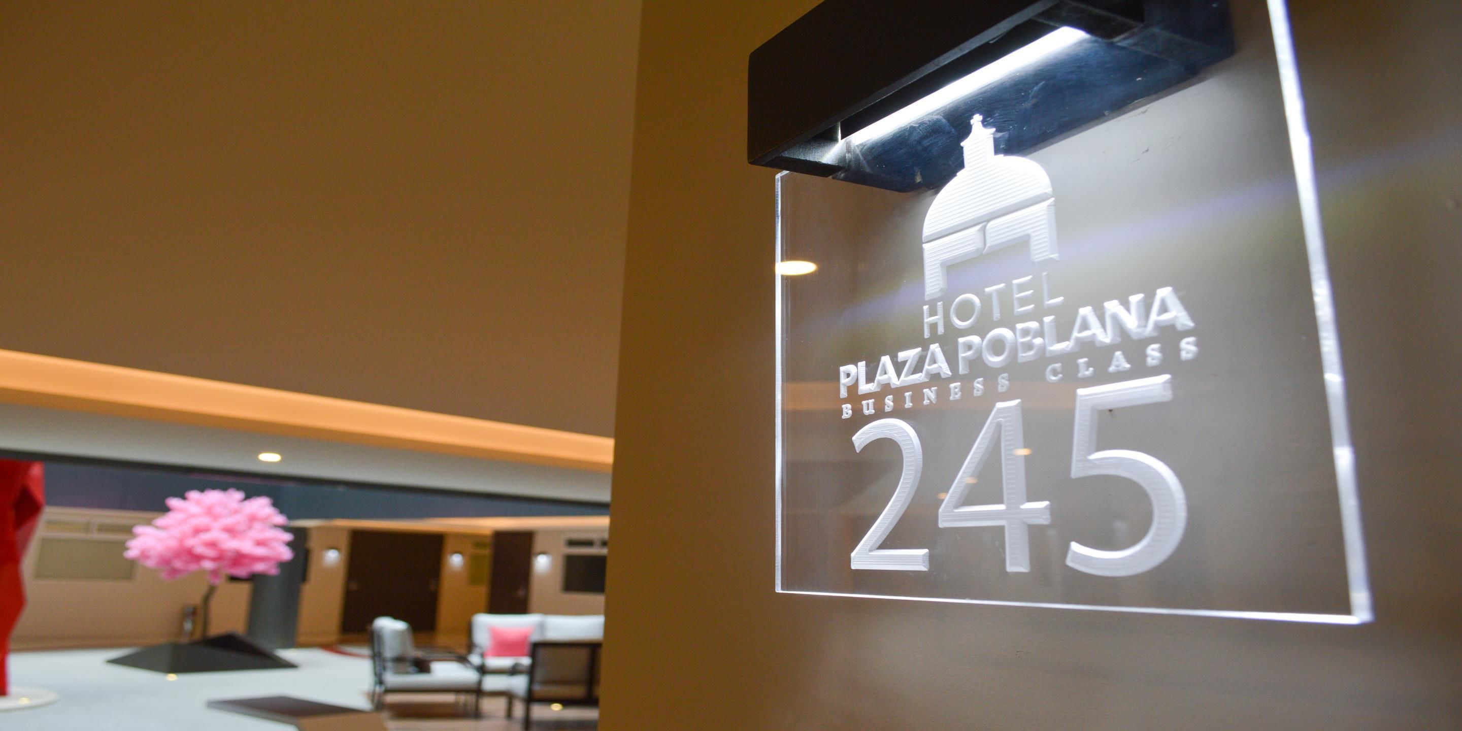 Letrero que indica Hotel Plaza Poblana, un hotel de clase empresarial, habitación 245.