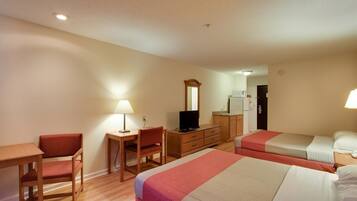 Habitación de hotel con dos camas, un escritorio, una silla, un televisor y un espejo.