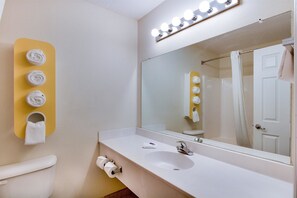 Une salle de bain avec un lavabo, un miroir et un porte-serviettes.
