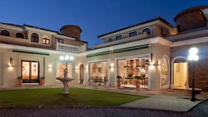 A well-lit courtyard with a fountain, multiple dining areas, and a large open kitchen. - Don Quijote Hotel (Búzios)