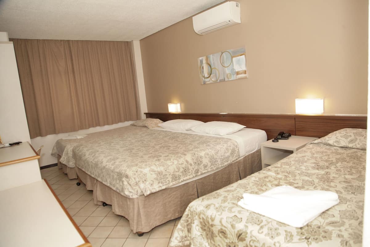 Une chambre d’hôtel avec deux lits, un bureau et une table de chevet.