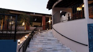 A staircase leading to a building with a balcony, surrounded by palm trees and outdoor lighting. - Hotel San Rafael Comfort Class (Foz do Iguaçu)