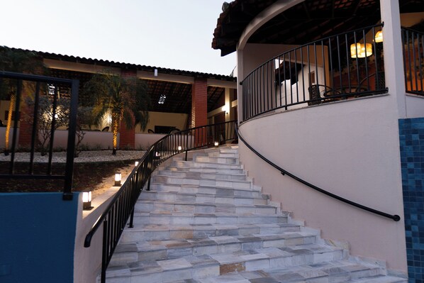 Una piscina al aire libre, sombrillas, sillones reclinables de piscina