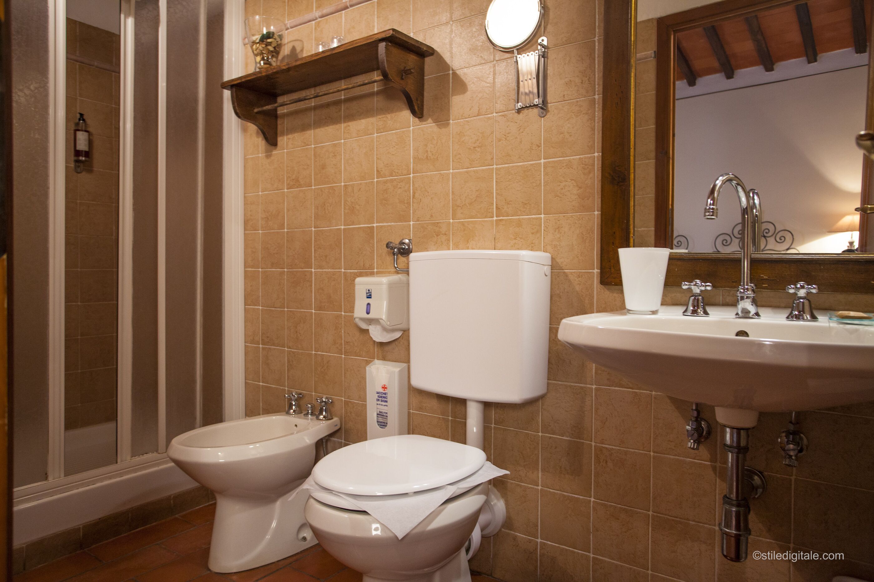 Un baño con dos inodoros, un lavamanos y una ducha.