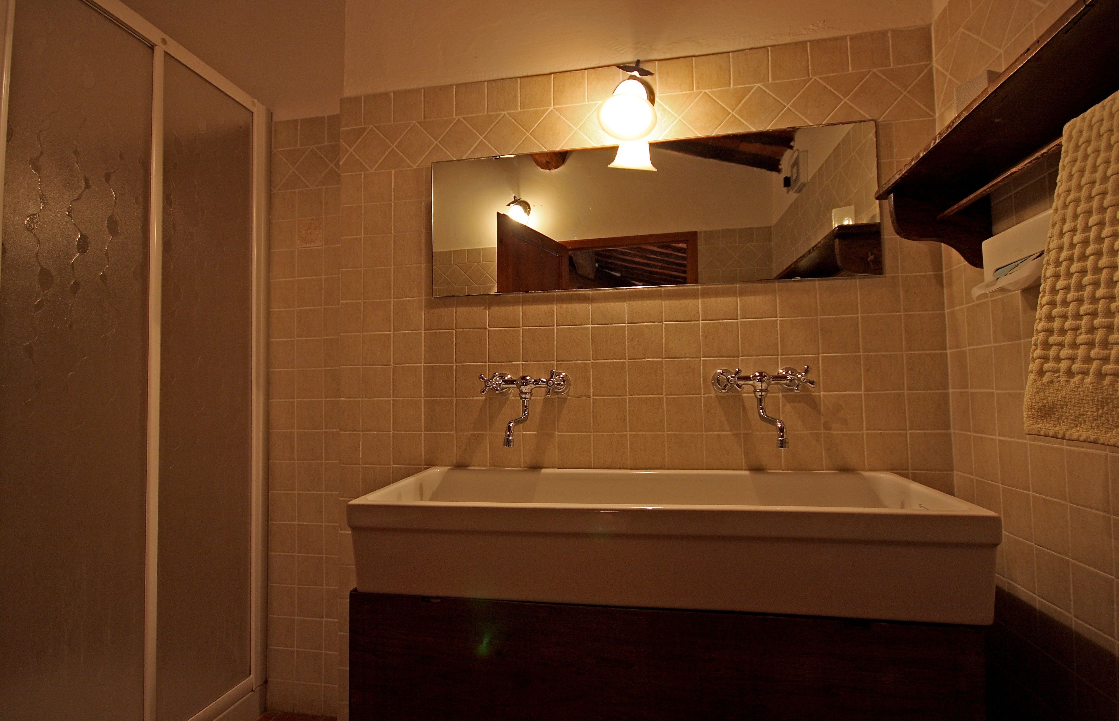 Une salle de bain avec un grand miroir, deux lavabos et un porte-serviettes.