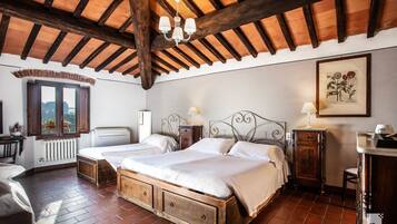 A bedroom with a wooden bed, two bedside tables, a window, a radiator, and a chandelier.
