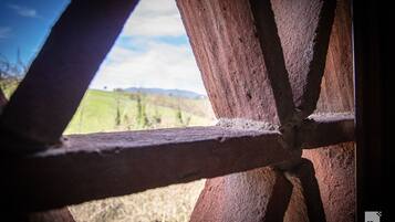 Una estructura de madera con vistas a un paisaje verde y colinas distantes.