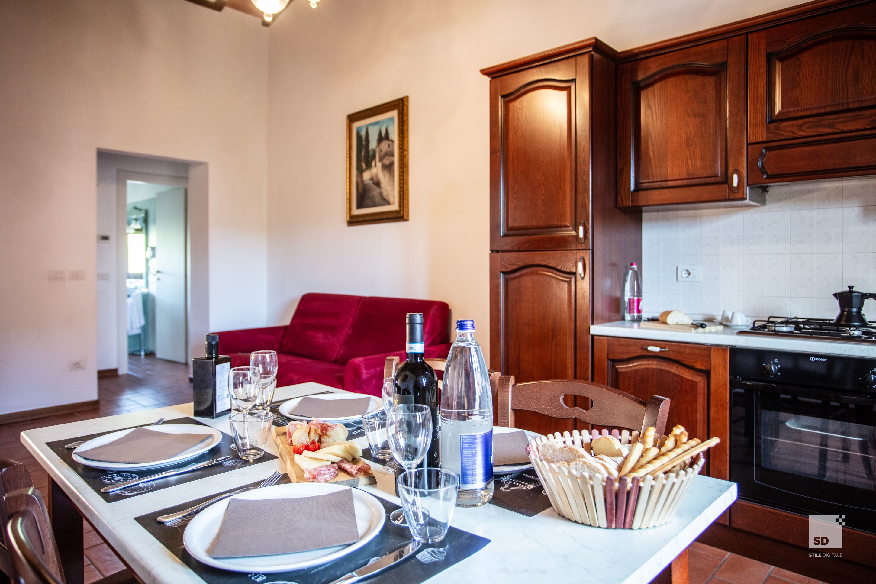 A dining table set with plates, cutlery, glasses, and a bottle of water.