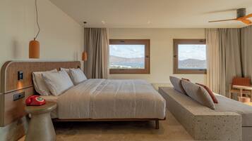 Un dormitorio con una cama, un sofá, un teléfono y dos ventanas con vistas.